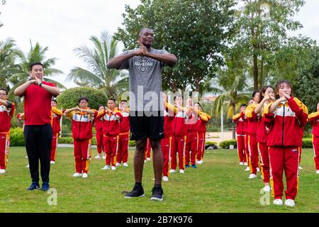 Dykembe Mutombo, avant, le joueur de basket-ball professionnel à la retraite congolais-américains joue du tai chi avec les gens à l'exercice du matin des 20 Banque D'Images