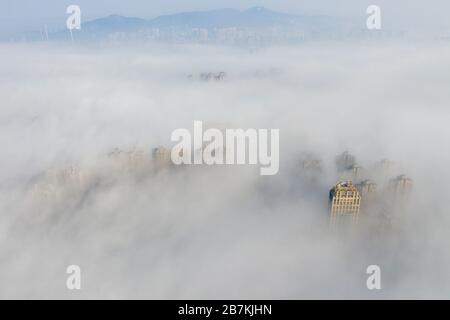 Les gratte-ciel sont enveloppés de brouillard dans la ville de Huaibei, province d'Anhui en Chine orientale, 12 février 2020. Banque D'Images
