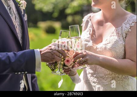 Épouse tenant un bouquet de fleurs et un verre de vin mousseux closeup mariage mariage Banque D'Images