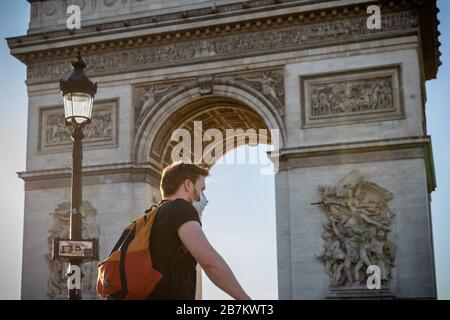 Pékin, France. 15 mars 2020. Un homme portant un masque de protection passe par l'Arc de Triomphe sur les champs-Élysées à Paris, en France, le 15 mars 2020. Samedi, le gouvernement a placé un verrouillage partiel dans le pays. Tous les lieux publics non essentiels, notamment les cafés, les boutiques, les restaurants et les discothèques, sont fermés jusqu'à nouvel ordre. Seules les épiceries, les pharmacies, les stations-service et les magasins de tabac sont autorisés à ouvrir leurs portes au public. Crédit: Aurelien Morissard/Xinhua/Alay Live News Banque D'Images