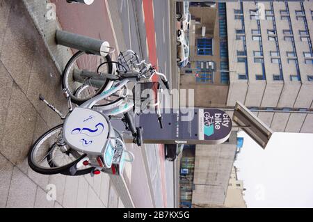 POZNAN, POLOGNE - 6 mars 2020: Deux vélos de location Nexbike par machine sur un trottoir humide dans le centre-ville. Banque D'Images