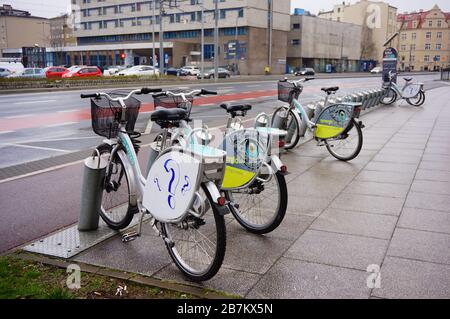 POZNAN, POLOGNE - 6 mars 2020: Rangée de vélos de location à louer sur un trottoir humide dans le centre-ville. Banque D'Images