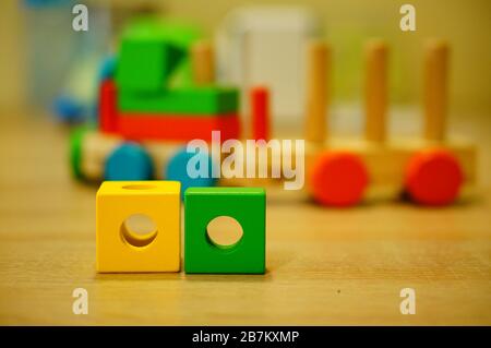 Gros plan de deux blocs de jouets en bois jaune et vert sur une surface en bois Banque D'Images