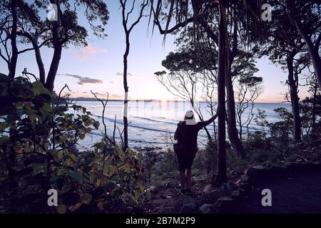 Petit groupe de personnes regardant le coucher du soleil au parc national Noosa, Noosa, Queensland, Australie Banque D'Images