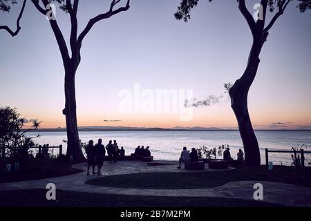 Petit groupe de personnes regardant le coucher du soleil au parc national Noosa, Noosa, Queensland, Australie Banque D'Images