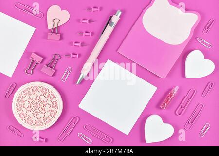 Poser à plat avec divers fournitures de bureau de papeterie disposées en rose comme le stylo, le carnet de notes, le papier à note vierge, les broches ou le clip de retenue Banque D'Images