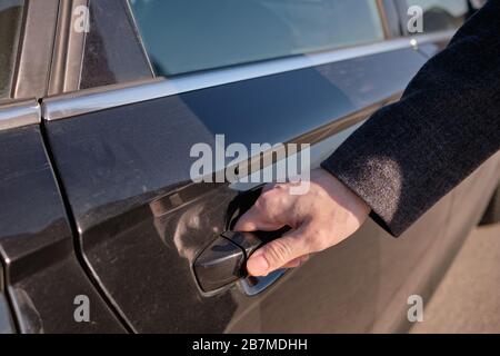 L'homme a fermé la porte arrière de la voiture en sortant. Gros plan. Banque D'Images
