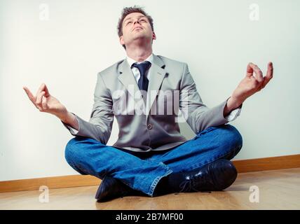 Portrait d'un travailleur indépendant faisant des exercices de relaxation à la maison assis à plusieurs pattes et les bras débordés Banque D'Images