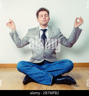 Portrait d'un travailleur indépendant faisant des exercices de relaxation à la maison assis à plusieurs pattes et les bras débordés Banque D'Images