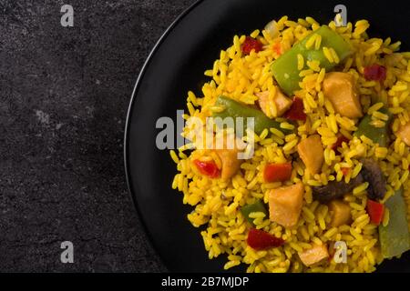 Riz frit avec poulet et légumes sur la plaque noire gros plan Banque D'Images