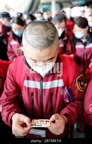 (200317) -- WUHAN, le 17 mars 2020 (Xinhua) -- le personnel médical Li Dongjiang de la province de Guizhou, dans le sud-ouest de la Chine, regarde son billet de train à la gare de Wuhan, dans la province de Hubei, dans le centre de la Chine, le 17 mars 2020. Le premier lot d'équipes d'assistance médicale a commencé à quitter la province de Hubei au début de mardi, alors que l'épidémie dans la province durement touchée a été subduite. Les 3 675 agents médicaux appartenant à 41 équipes médicales de toute la Chine ont aidé 14 hôpitaux temporaires et sept hôpitaux désignés à Wuhan, la capitale provinciale et l'épicentre de l'épidémie. (Xinhua/Shen B Banque D'Images