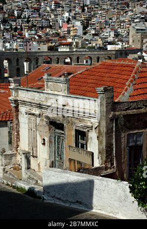 Ancienne maison ruinée à vendre le jour ensoleillé d'été avec la ville en arrière-plan. Banque D'Images