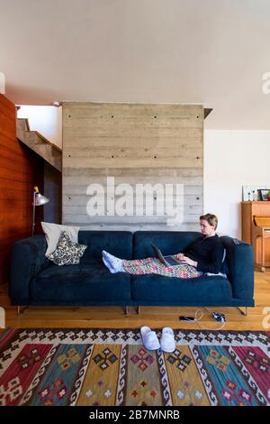 femme dans la salle de séjour à la maison avec ordinateur portable Banque D'Images