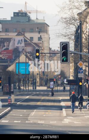 Ljubljana, Slovénie - 17 mars 2020: Feux de circulation au centre-ville de Ljubljana, Slovénie sur des rues presque vides avec peu de cyclistes et de pedes Banque D'Images