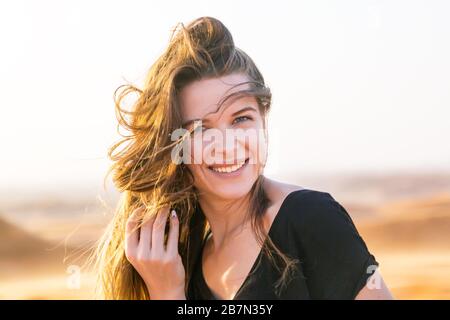 Caucasienne fille dans une robe noire avec de longs cheveux blonds, la proximité du visage. Banque D'Images