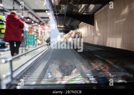 17 mars 2020, Bade-Wuerttemberg, Göppingen: Un client de supermarché passe devant une étagère vide. En raison des achats de hamster, de nombreux produits ne sont plus disponibles dans le supermarché. Photo : Tom Weller/dpa Banque D'Images