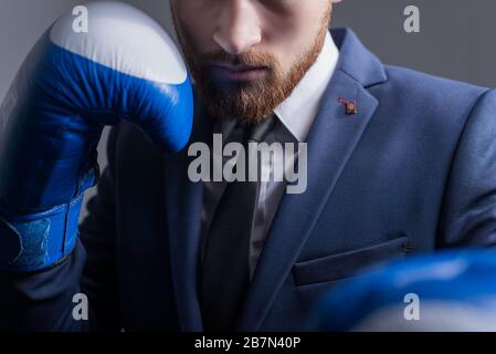 plan principal, studio portrait dramatique d'un jeune homme barbu de vingt-cinq ans, un homme en costume d'affaires, regardant l'appareil photo, tenant Banque D'Images