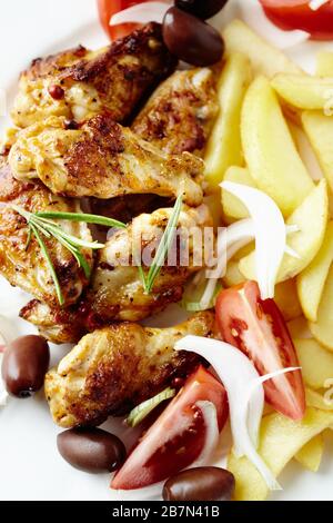Ailes de poulet rôties au romarin frais, frites et tomates. Vue de dessus. Banque D'Images