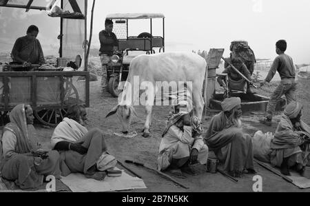 Groupe de hindous, quelques mendiants recherchant des alms, femme vendant du thé, vache Sainte, et d'autres près de la rivière Yamuna à Vrindavan, en Inde. Banque D'Images