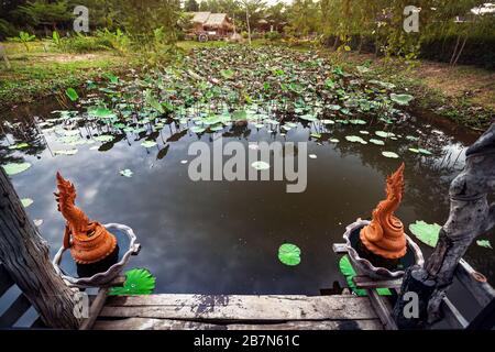 Magnifique étang avec lotus et Dragon des statues dans Sukhothai resort, Thailande Banque D'Images