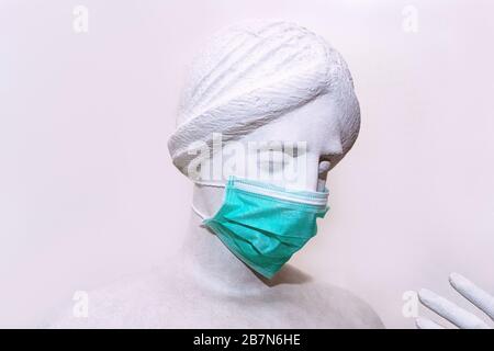 Chef de sculpture d'une ancienne femme dans un masque de protection pour l'anti-infection des malades respiratoires. Éclosion du concept de coronavirus. Nouveau coronavirus - 2019-nCoV. L'inscription Stop Coronavirus COVID-19. Banque D'Images