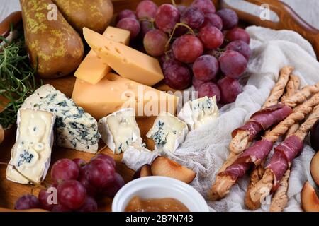 L'antipasto. Plat avec croustillant de grissini enveloppé de bacon séché au soleil, tranches de fromage brie, camembert, fromage bleu, radamer et muscat Grape Vine avec fru Banque D'Images