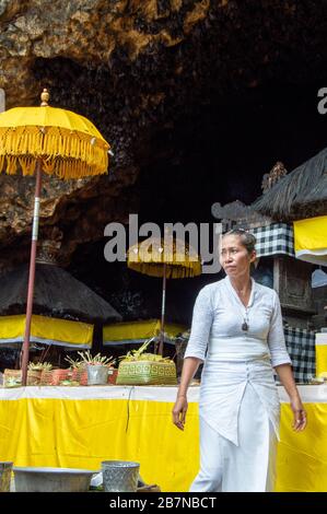 Femme devant la réception votive située en face de la grotte de la chauve-souris. Célébration Odalan, Pura Goa Lawah, Semarapura, Bali, Indonésie Banque D'Images