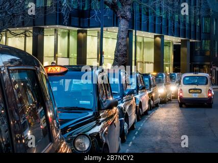 Royaume-Uni, Angleterre, Londres. Une station de taxis avec des taxis londoniens noirs Banque D'Images