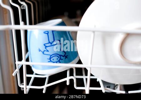 Plats pour enfants au lave-vaisselle. Nettoyez la tasse et la soucoupe. Banque D'Images