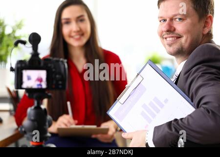 Les jeunes hommes et femmes d'affaires positifs discutent de statistiques rapport Banque D'Images