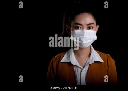 Femme d'affaires de la jeune femme d'Asie mettant sur un masque respiratoire N 95 pour protéger contre les maladies respiratoires aéroportées comme les PM2,5 de coronavirus covid-19 de grippe Banque D'Images