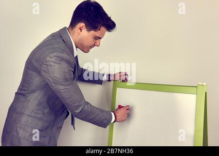 Jeune homme écrit sur le tableau blanc Banque D'Images