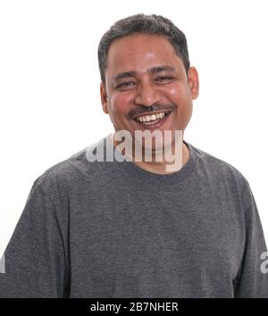 Un homme indien souriant dans un studio avec un fond blanc regardant l'appareil photo Banque D'Images