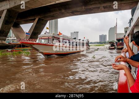 Trafic en bateau sur la rivière Chao Phraya dans le centre de Bangkok, Thaïlande, près du pont Taksin et de la jetée de Sathon Banque D'Images