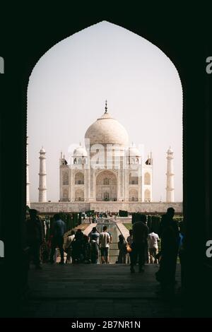 Le Taj Mahal a vue à travers une porte et beaucoup de touristes devant les escaliers Banque D'Images