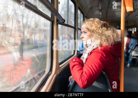 Femme blonde d'Europe de l'est ayant une balade dans les transports publics, regardant dans la fenêtre. Banque D'Images