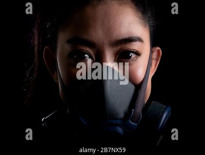 Gros plan femme d'affaires de la jeune femme d'Asie mettant sur un masque respiratoire N 95 pour protéger contre les maladies respiratoires aéroportées comme la grippe covid-19 coronavi Banque D'Images