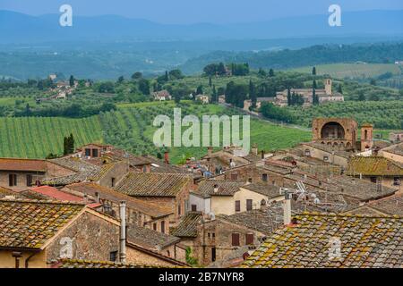 Toits de San Gimignano, campagne toscane avec collines ondulantes et Santa Maria Assunta a Monte Oliveto Minore de Parco della Rocca, San Gimignano Banque D'Images