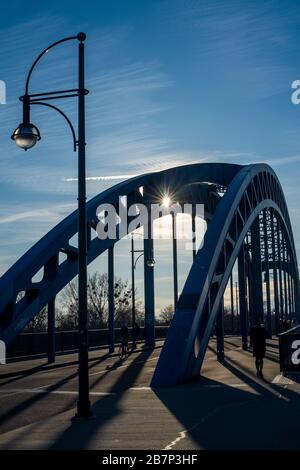 Magdeburg, Allemagne. 17 mars 2020. Les marcheurs traversent un pont d'Elbe au coucher du soleil. Beaucoup de gens profitent de l'après-midi ensoleillé pour faire de l'exercice à l'extérieur. Il devrait rester ensoleillé et doux dans les jours à venir. Crédit: Klaus-Dietmar Gabbert/dpa-Zentralbild/dpa/Alay Live News Banque D'Images