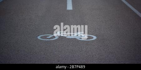 détail d'un panneau de signalisation d'un vélo peint en blanc sur l'asphalte dans une piste cyclable Banque D'Images