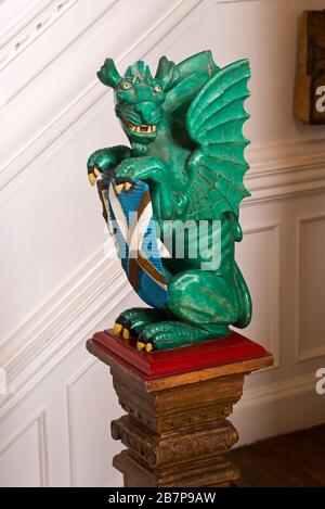 Un dragon sculpté tenant les armoiries sur l'escalier principal de la Bishops House I The Bishops Palace à Wells, Somerset, Angleterre, Royaume-Uni Banque D'Images