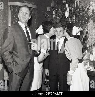 Années 1960, des boxers britanniques célèbres, Henry Cooper et Terry Spinks visitant un hôpital à l'heure de Noël à Lewisham, en Angleterre du Sud-est, au Royaume-Uni, avec deux femelles donnant un baiser à Terry et Henry pour me demander ce qui me concerne. Le sud-est de Londres Henry Cooper, né en Grande-Bretagne, est devenu le premier boxeur britannique à être fait chevalier. Banque D'Images