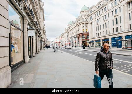 Un homme solitaire marche le long d'une rue vide Regent's Street pendant la pandémie de virus Corona / Covid-19, Londres, Royaume-Uni. 17 mars 2020. Banque D'Images
