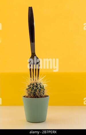 Cactus de mode tropical et fourchette noire sur fond jaune. Style et couleurs pop-art tendance et minimalistes.concept créatif tendance d'été. Minimale Banque D'Images