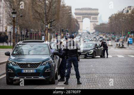 Paris, France. 17 mars 2020. Les policiers vérifient les voitures sur l'avenue champs-Elysées à Paris, France, 17 mars 2020. La France a détecté 7 730 cas d'infection par le coronavirus et 175 personnes sont mortes du virus, a annoncé mardi le directeur général de la Santé, Jérôme Salomon, lors d'une mise à jour quotidienne. Mardi midi, la France a été mise en service pendant au moins 15 jours. Seuls les voyages vraiment nécessaires, comme pour des raisons professionnelles ou sanitaires ou pour acheter des aliments, sont autorisés. Crédit: Aurelien Morissard/Xinhua/Alay Live News Banque D'Images