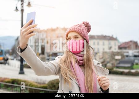 Femme portant un masque corona rendant selfie avec le téléphone Banque D'Images