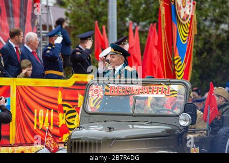 Anapa, Russie - 9 mai 2019: Vétéran dans une vieille voiture militaire accueille des figures honorifiques sur la place du théâtre d'Anapa pour la célébration du jour de la Victoire Banque D'Images