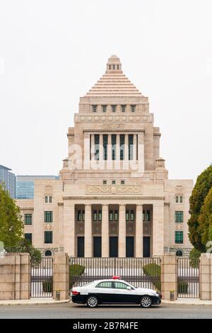 Bâtiment national de régime avec une voiture de police pendant dans un jour nuageux. Le bâtiment national de régime alimentaire est le bâtiment où les deux maisons de l'alimentation nationale de Banque D'Images