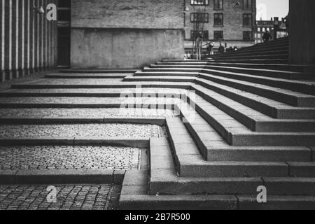 Des escaliers en pierre et en galets en public, dans la ville de Copenhague, au Danemark. Lignes angulaires solides qui mènent l'œil vers le haut. Image en noir et blanc. Banque D'Images