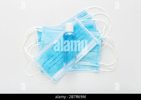 Protection contre le coronavirus. Masques chirurgicaux de protection médicale, gel désinfectant pour les mains sur table blanche. Solution désinfectante antibactérienne pour savon à base de gel d'alcool, mains Banque D'Images